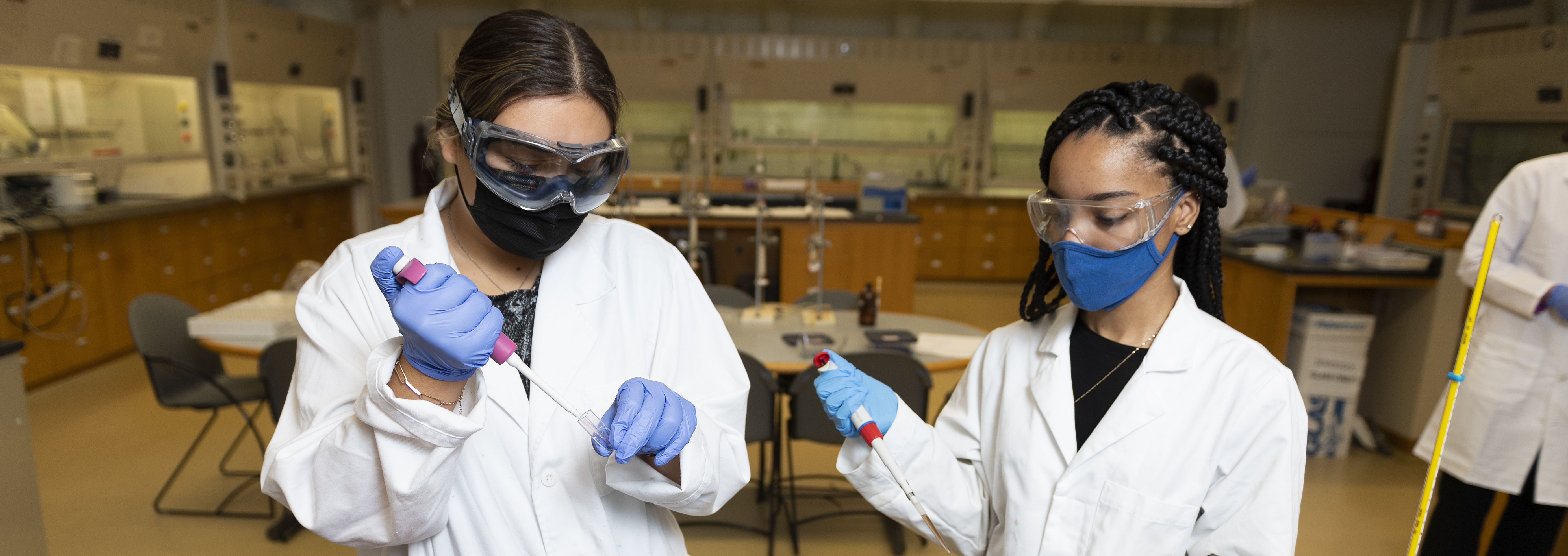 Two young women in lab coats in a chemistry lab
